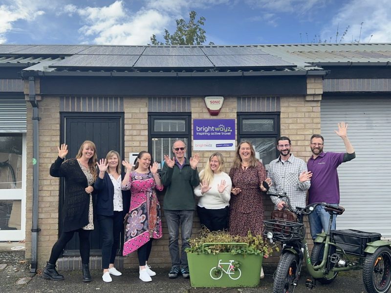 Shows the Brightwayz team outside the Brightwayz office with one of our planters in front and newly installed solar panels.