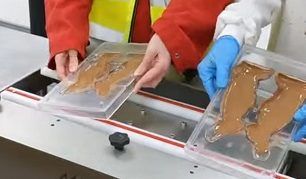 Shows people making chocolate Easter bunnies
